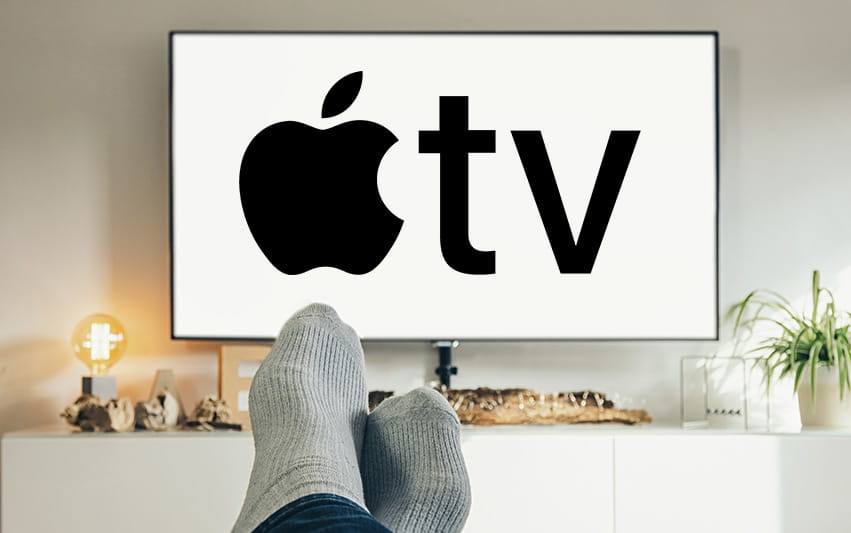 Frau schaut Apple TV auf Couch mit Popcorn