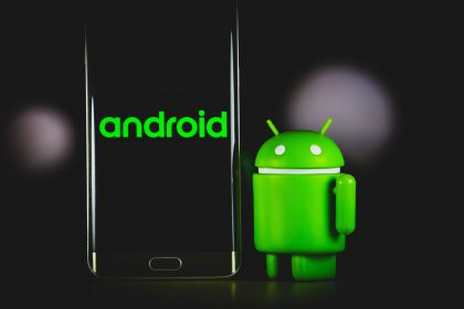 Das Android-Symbol und ein Android-Smartphone vor einem schwarzen Hintergrund
