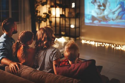 Familie sitzt zusammen vor dem Fernseher