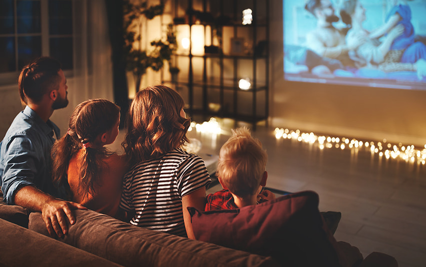 Familie sitzt zusammen vor dem Fernseher