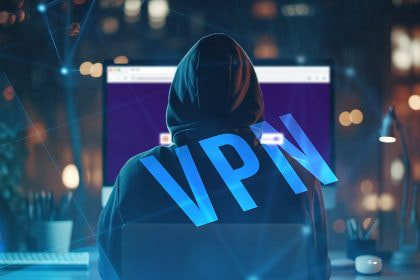 Eine Person mit Kaputze vor einem Bildschirm.